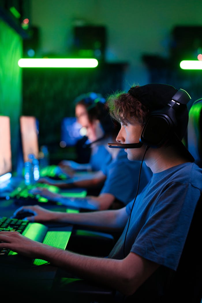 brand-02 Intense gaming session with teens in a cybersport competition, illuminated by vibrant green lighting.