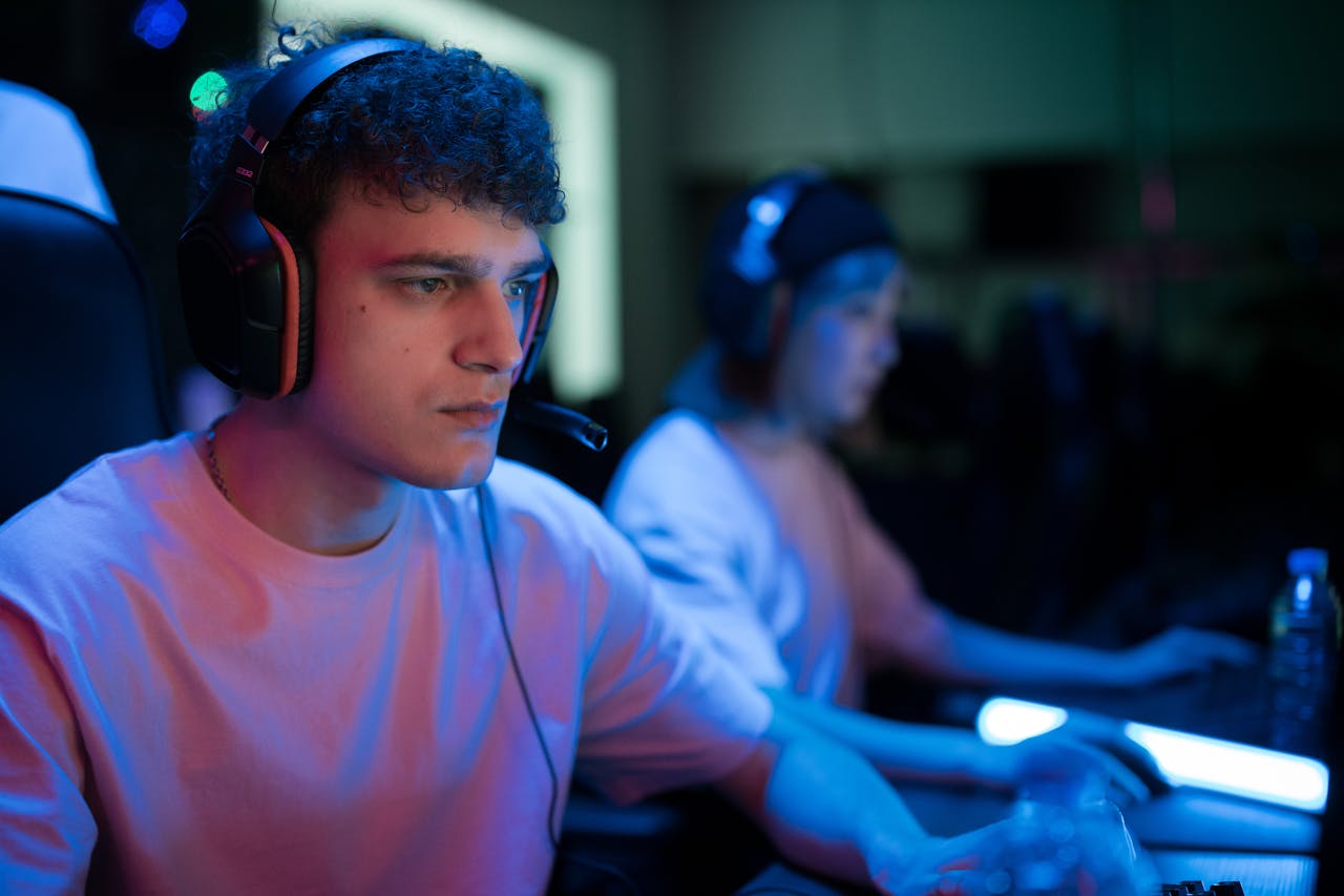digital-01 Man with headset engaged in intense gaming session under neon lights.